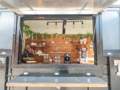 A coffee bar setup with coffee machine popcorn maker and cups inside a black food truck at Bell tent 2 Camerton near Timsbury