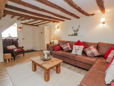 A living room with a sofa and armchair at High Ickenthwaite Farmhouse in Ulverston