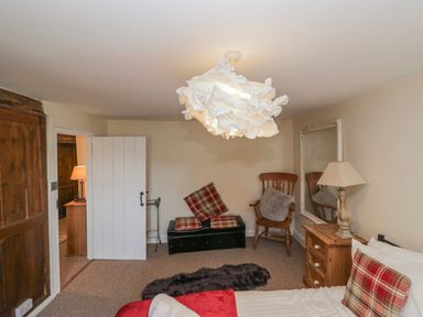 A bedroom with a bed and seating area at High Ickenthwaite Farmhouse in Ulverston
