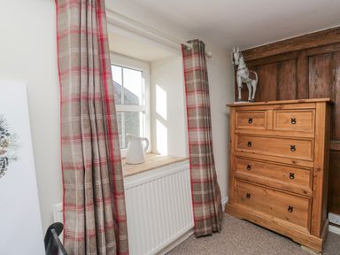 A bedroom with a window and chest of drawers at High Ickenthwaite Farmhouse in Ulverston