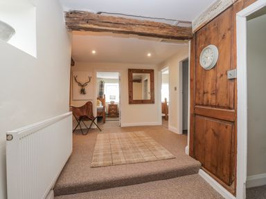 A hallway with a radiator and a mirror at High Ickenthwaite Farmhouse in Ulverston
