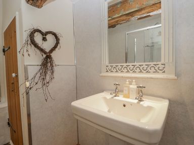 A sink with a mirror and toiletries at High Ickenthwaite Farmhouse Ulverston