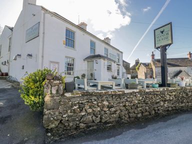 An outdoor view of the Manor House showing tables and chairs at High Ickenthwaite Farmhouse Ulverston