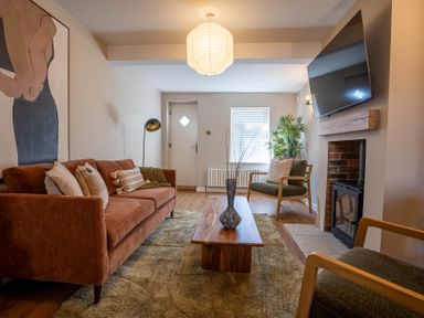 A living room with a sofa chairs coffee table fireplace and a wall mounted TV at Driftwood in Kessingland