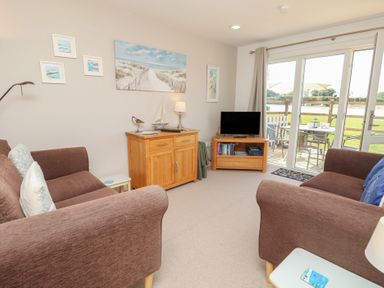 A living room with a sofa and television at Plimoth N8 in Yarmouth