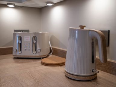 A kitchen countertop with a toaster and an electric kettle at The Reef in Kessingland