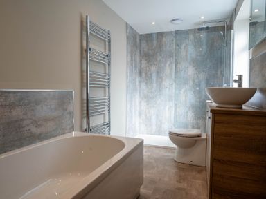 A bathroom with a bathtub toilet sink and shower at The Reef in Kessingland