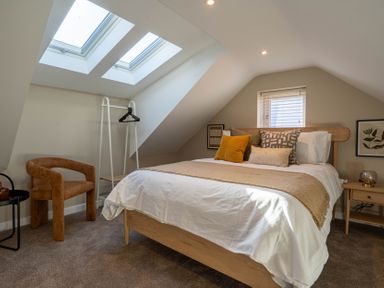 A bedroom with a bed with pillows under skylight windows at Coral Cottage in Kessingland