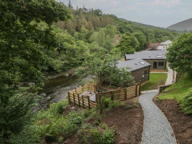 An outdoor area with a river and buildings at Hodge Luxury Pod in Keswick