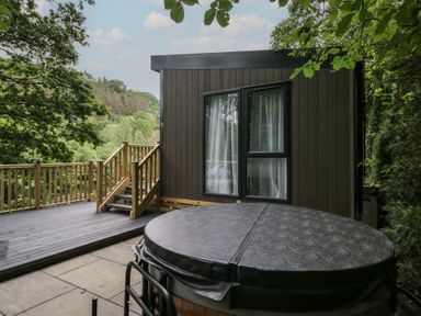 An outdoor area with a hot tub and decking at Hodge Luxury Pod in Keswick