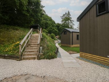 An outdoor area with cabins, a path, and stairs at Dubs Luxury Family Pod in Keswick
