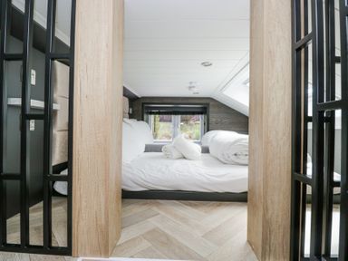 A bedroom with a bed and rolled towels on it at Lingy Luxury Family Pod in Keswick