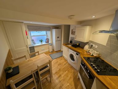 A kitchen with a table and chairs at Hocking Cottage St Marychurch