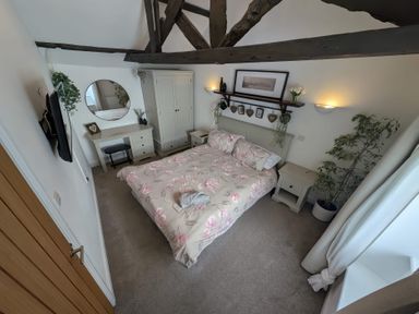 A bedroom with a bed and desk at Hocking Cottage in St Marychurch