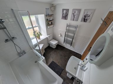 A bathroom featuring a bathtub, shower, toilet, and sink at Hocking Cottage St Marychurch