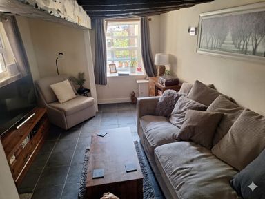 A living room with a sofa and coffee table at Hocking Cottage in St Marychurch