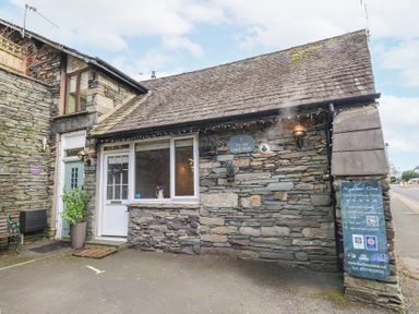 The exterior of a stone building with a white door and window at 1 The Old Coach House Ambleside