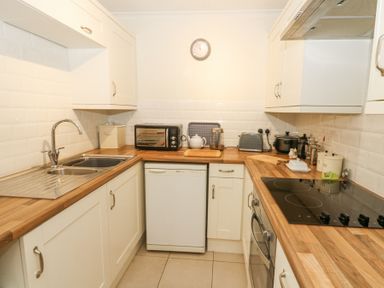 A kitchen with wooden countertops a sink a stove toaster and oven at Carningli Suite near Newport