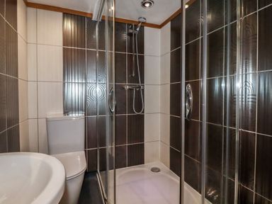 A bathroom with a shower enclosure a toilet and a sink at St Saviours in Padstow