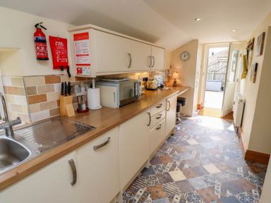 A kitchen with a countertop sink microwave toaster knives and stools at Folly View in Eglingham