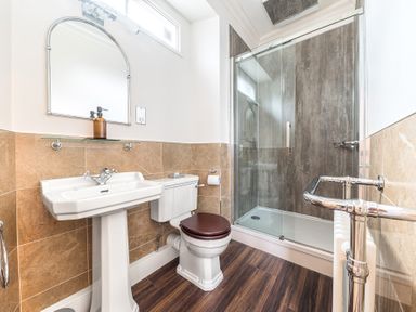 A bathroom with a pedestal sink toilet and glass shower enclosure at Fir Trees in Windermere