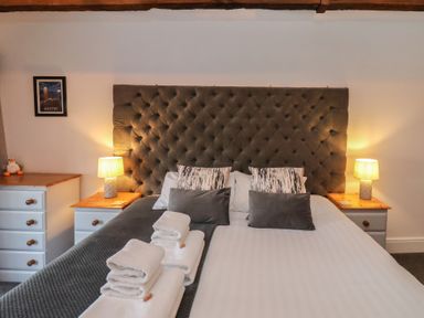 A bedroom with a bed with pillows and folded towels on it and two bedside tables with lamps at Duchess of Hamilton @ Engine Shed in Whitby