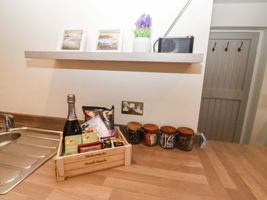 A kitchen with a basket of snacks and drinks at North Sands Beadnell
