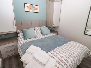 A bedroom with a bed and wardrobe at North Sands in Beadnell