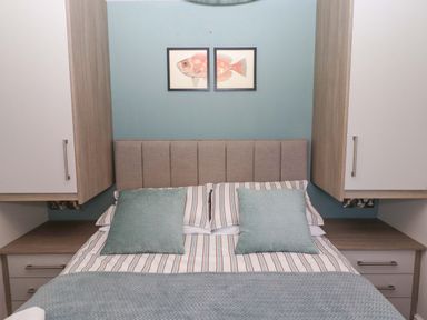 A bedroom with a bed and wall art at North Sands Beadnell