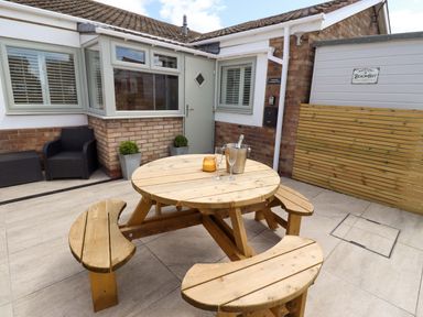 An outdoor seating area with a table and benches at North Sands Beadnell
