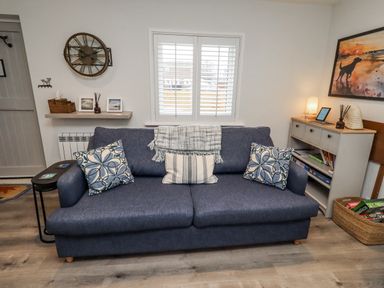 A living room with a sofa and shelves at North Sands in Beadnell