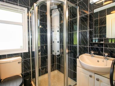 A bathroom with a shower, toilet, and sink at Dunromin Montgomery