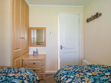 A bedroom with two beds and a mirror at Dunromin in Montgomery