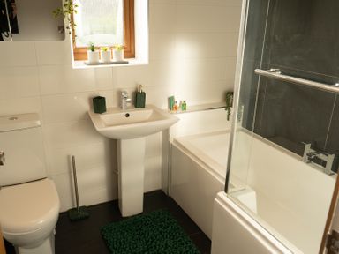 A bathroom with toilet sink bathtub and plants on the window sill at The Green Monkey in North Hykeham