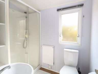A bathroom with a shower cubicle a toilet a pedestal sink and a window at 31B Foxburrow Hang in Fritton near Belton Norfolk