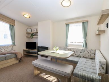 A living room with seating area dining table and television at 31B Foxburrow Hang in Fritton near Belton Norfolk