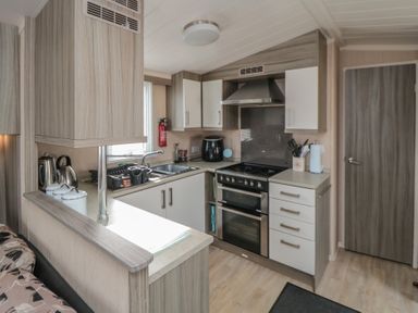 A kitchen with stove oven sink cabinets and countertop at Rose Bank D8 in Primrose Valley