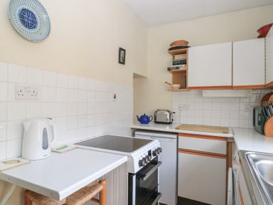A small kitchen with a stove kettle and toaster at The Townhouse in Salisbury