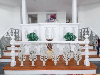 A staircase with ornate white and gray railings and potted plants at Trelowth Chapel in Polgooth