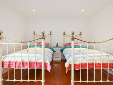 A bedroom with two single beds and a nightstand between them at Trelowth Chapel in Polgooth