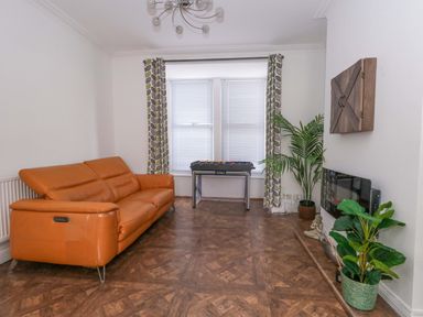 A living room with a sofa, foosball table and plants at Weymouth Seaside House in Weymouth