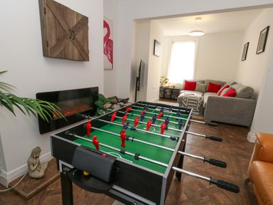 A living room with foosball table and sofa at Weymouth Seaside House in Weymouth