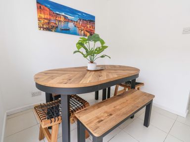 A dining room with a wooden table and plant at Weymouth Seaside House in Weymouth