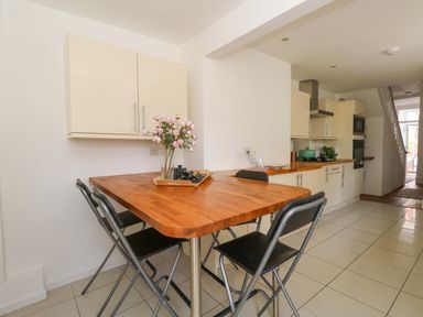 A kitchen with a table and chairs at Weymouth Seaside House in Weymouth