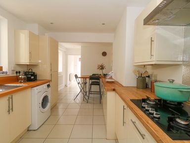 A kitchen with appliances and a table at Weymouth Seaside House in Weymouth