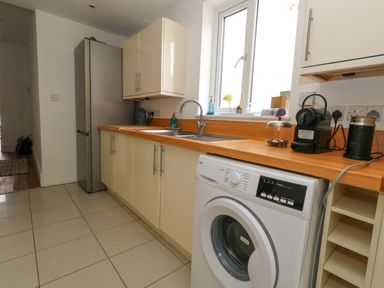A kitchen with sink and washing machine at Weymouth Seaside House in Weymouth