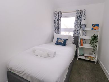 A bedroom with a single bed and a bookshelf at Weymouth Seaside House in Weymouth
