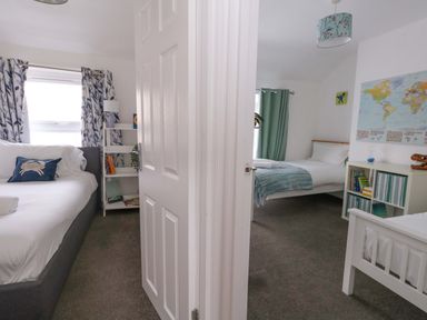 A bedroom with two beds and a window at Weymouth Seaside House in Weymouth