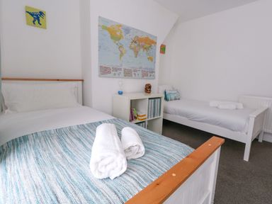 A bedroom with two beds and a map on the wall at Weymouth Seaside House in Weymouth