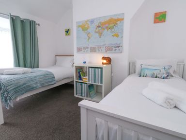 A bedroom with two beds and a map on the wall at Weymouth Seaside House in Weymouth